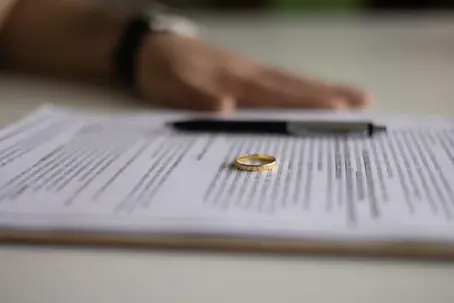 a wedding ring and paperwork about to be signed